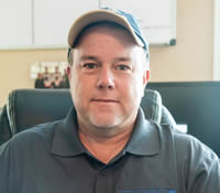 a man sitting in a chair wearing a hat