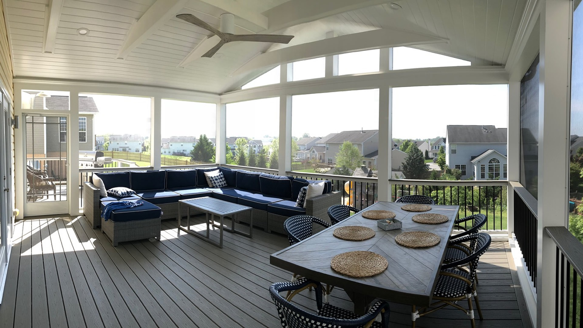 a covered porch with a table and couches