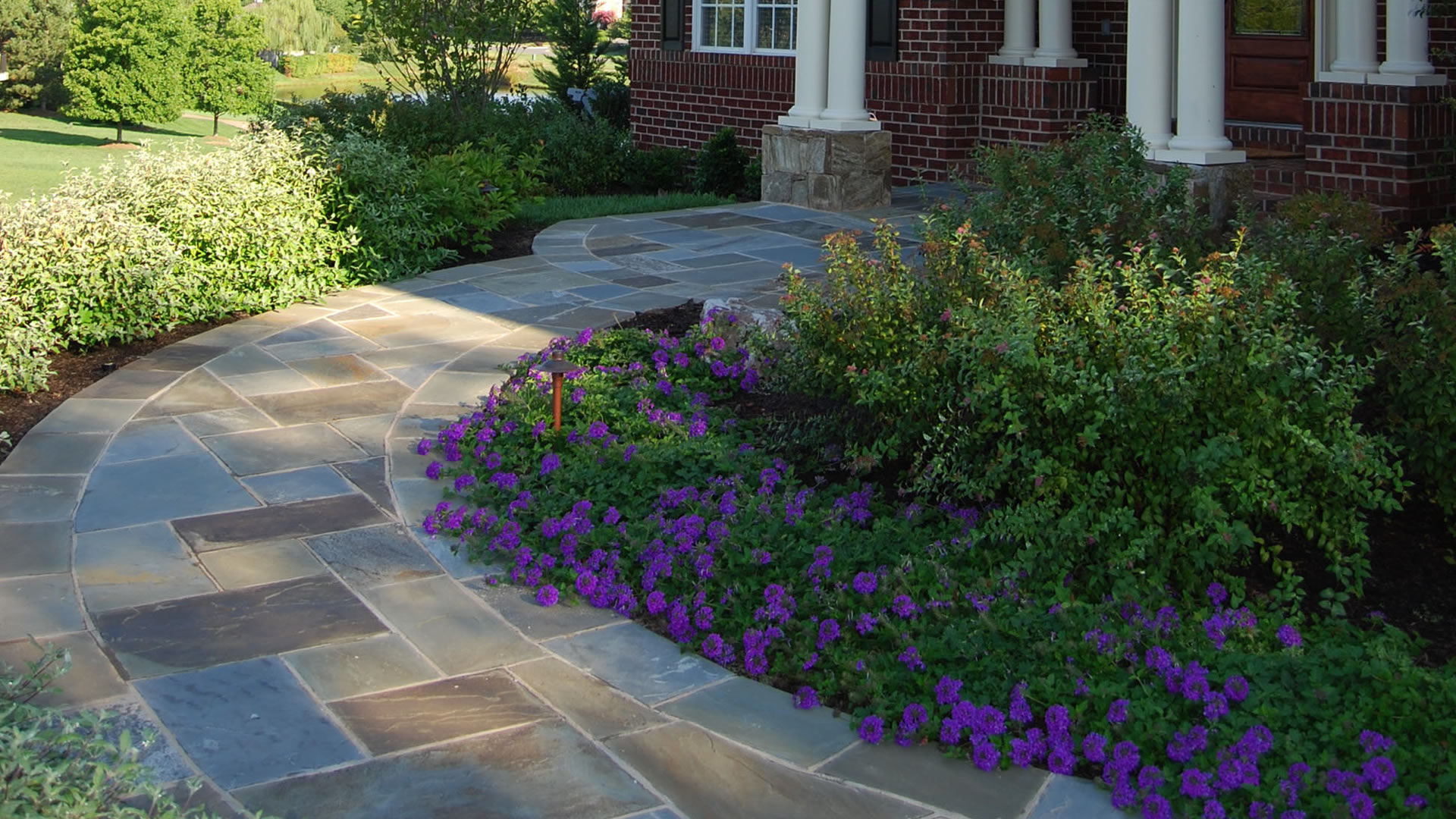 a brick house with a stone walkway leading to the front door