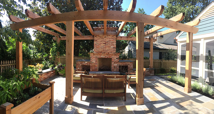 A stone pavers patio with a big wooden pergola overhead to provide shading