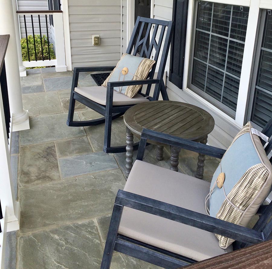 Two rocking chairs resting on the front porch of a home