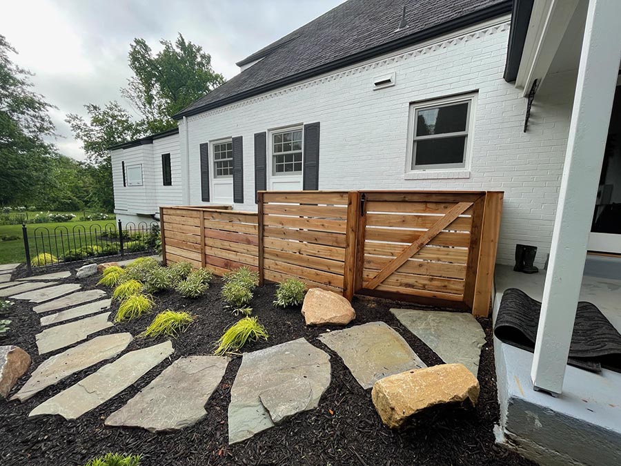 A stone pathway through mulch leading to a front porch