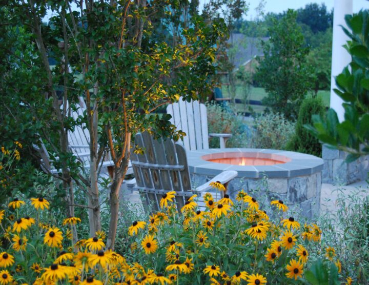 A stone gas-burning fire pit installed by Outdoor Spaces