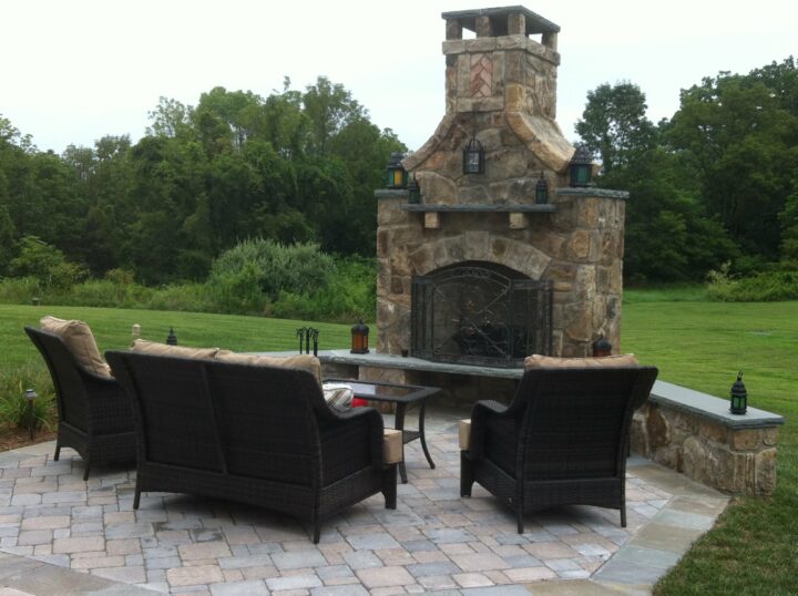 A backyard patio with a stone fireplace