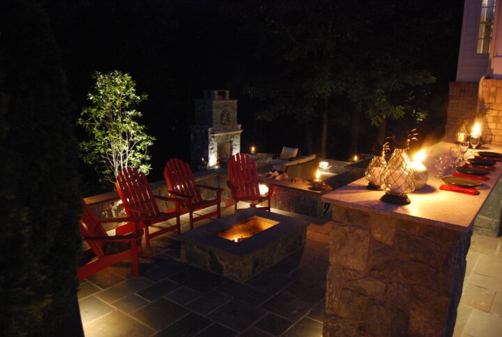 A backyard patio with outdoor lighting to accent features in the darkness