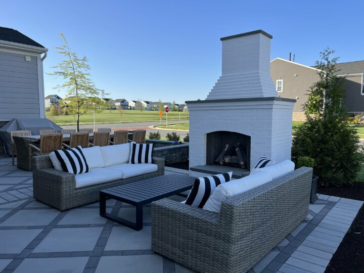 A backyard patio with couches and a fireplace