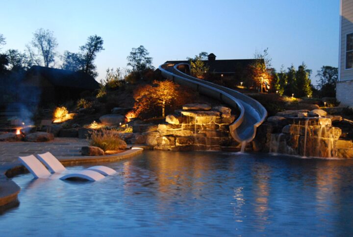 A residential pool with a metal water slide attached