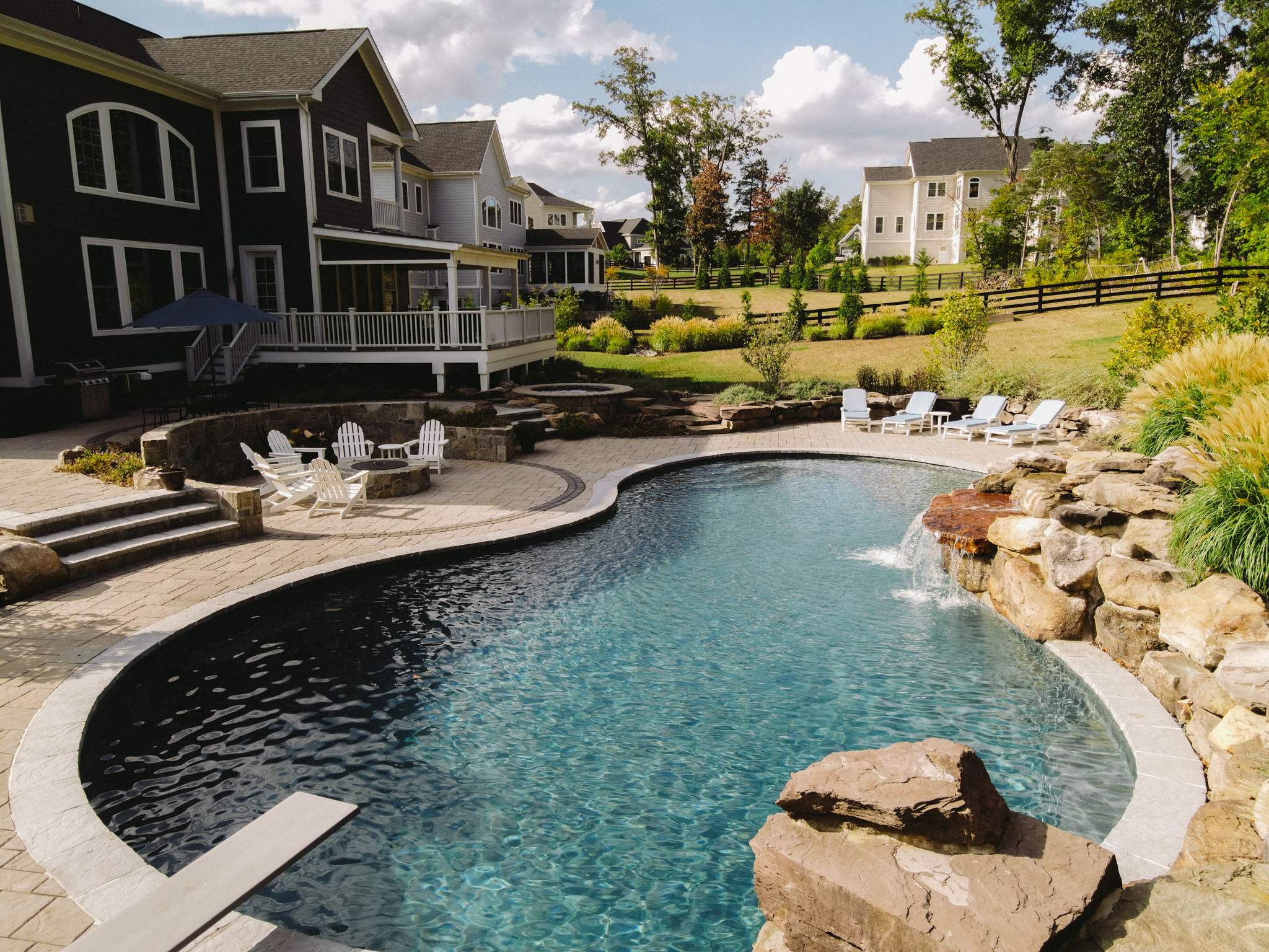 A pool with a stone patio next to it.