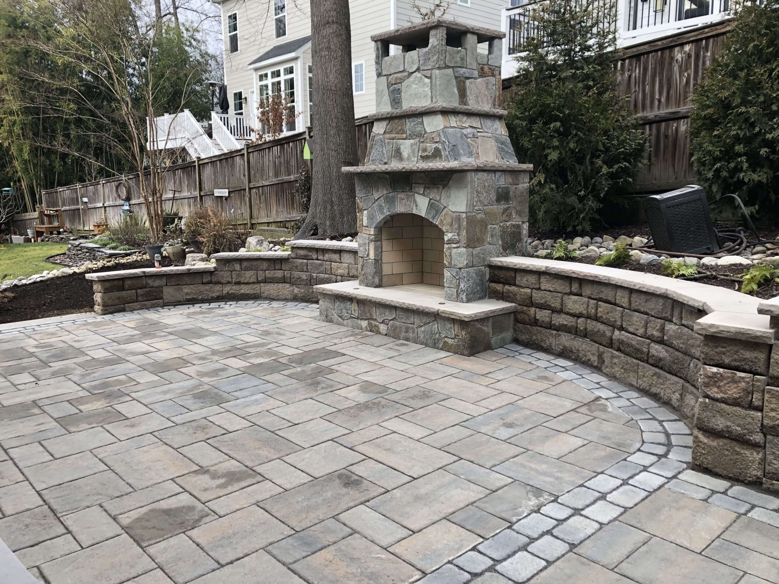 Circular pavers patio with a stone fireplace