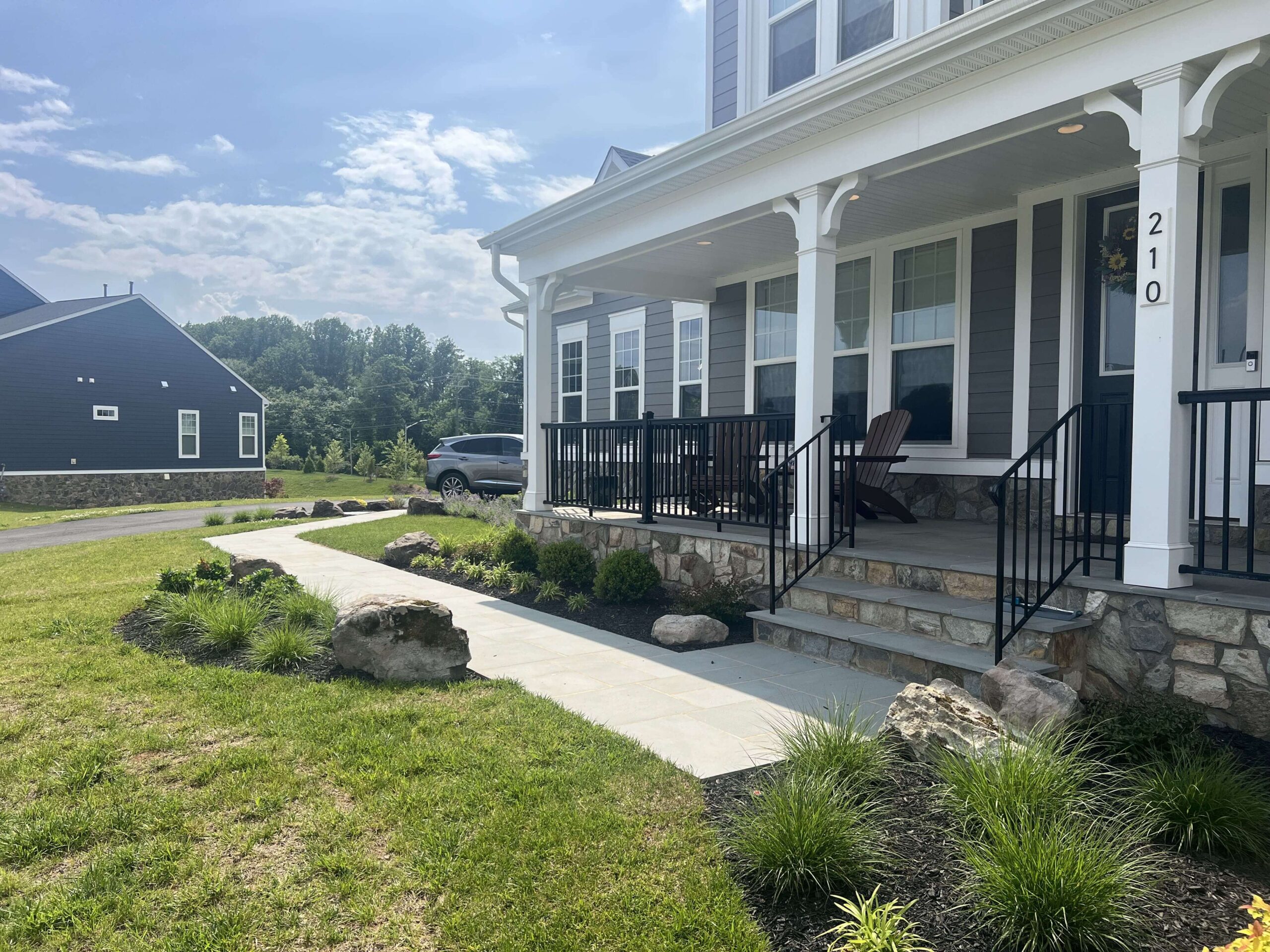A house with a green lawn and a pavers walkway leading up to the entrance.