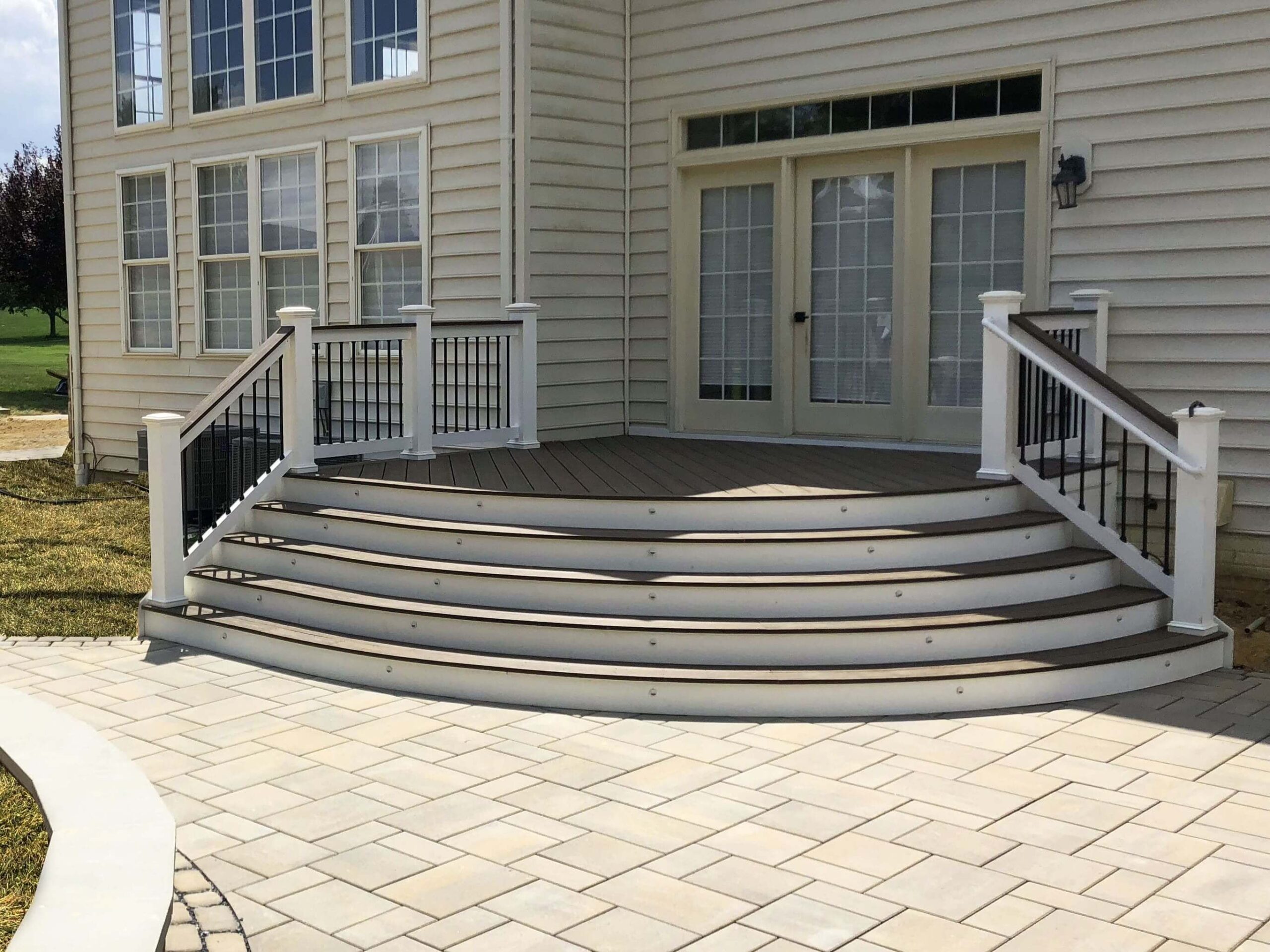 A back porch leading down to a pavers patio.