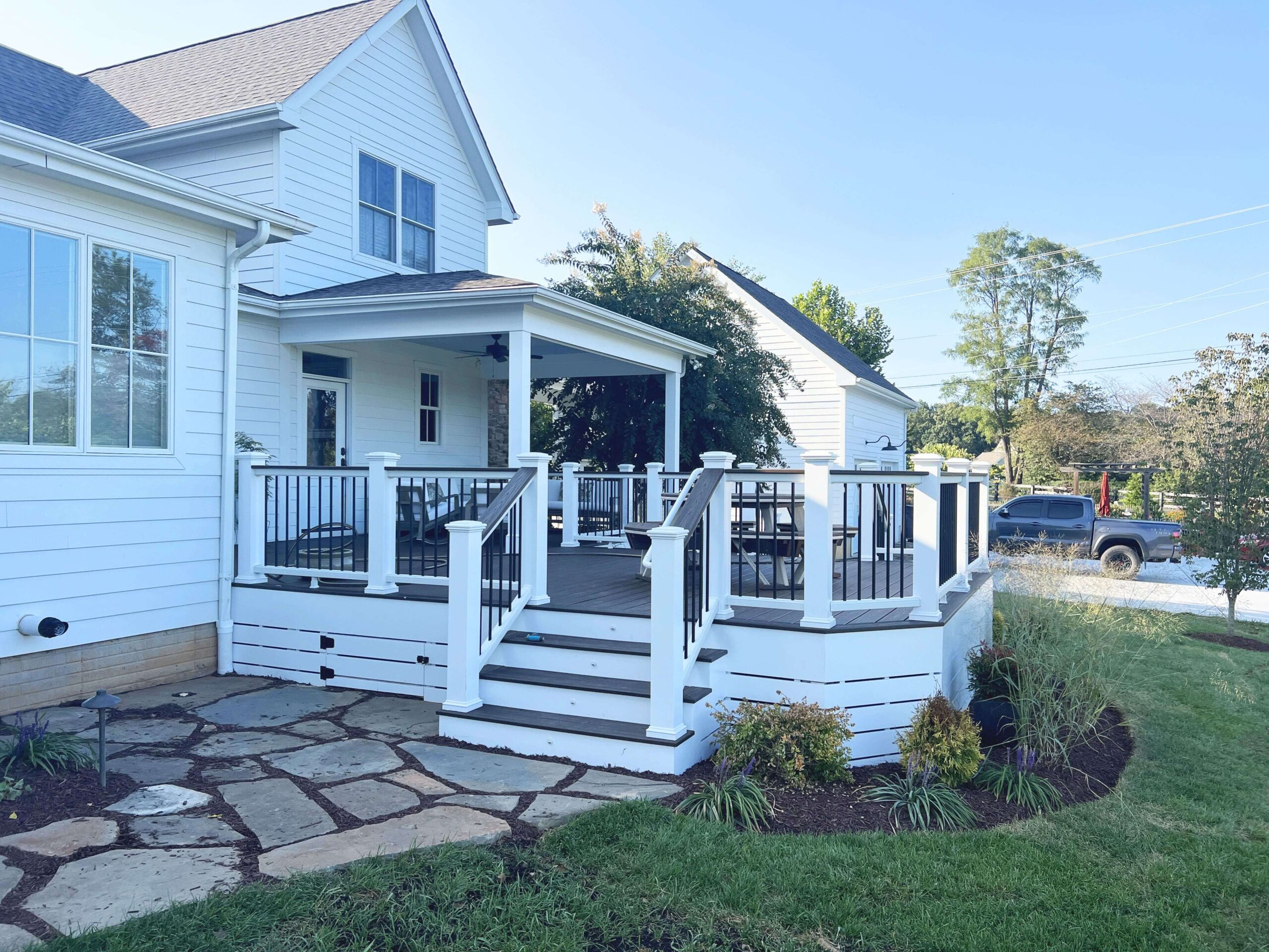 A back porch leading down to a quarried stone patio.