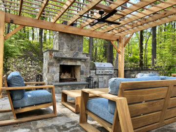 A cedar pergola with an outdoor fireplace and grill station.