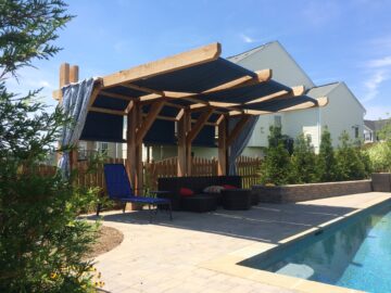 A poolside pergola with retractable fabric shades.