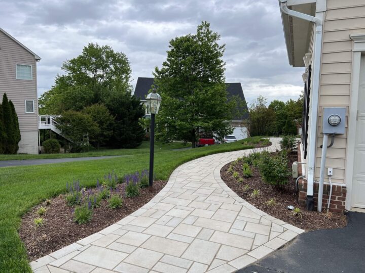 A pavers walkway in front of a home connected to the driveway.