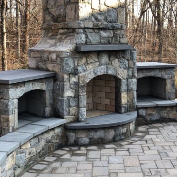 An outdoor fireplace with curved stone hearth for extra comfort.