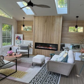 A minimalist electric outdoor fireplace with vertical wood paneling.