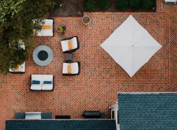 A brick patio with a fire pit and umbrella