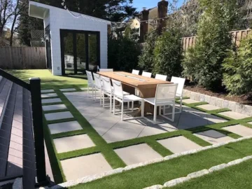 Modern outdoor dining area with turf separating concrete slabs